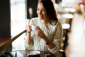 Portrait of happy young woman in cafe