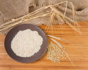 Fototapeten Raw fine-ground barley groat, barley whole grains and ears © An-T