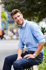 Smiling guy in blue shirt in city