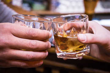 Cheers. two friends drinking whisky at the bar