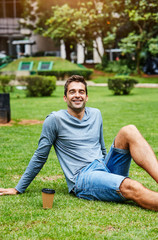 Naklejka na ściany i meble Smiling guy relaxing in park, portrait