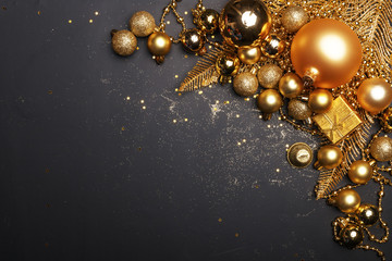Christmas composition of golden Christmas toys and decoration elements on a black background.