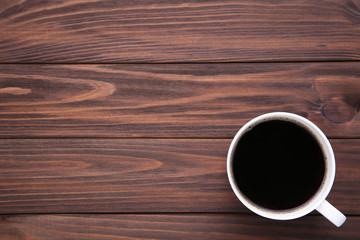 Cup of coffee on brown wooden background