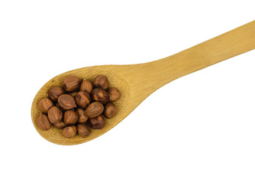 Large wooden spoon with hazelnuts isolated on white background.