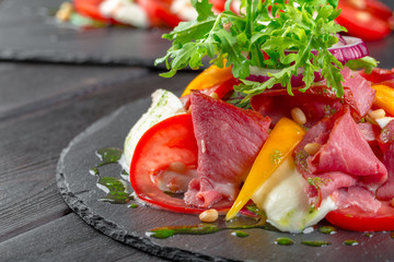 Fresh Tasty Persimmon salad with arugula, parma ham, olive oil and herbs. autumn, winter healthy...
