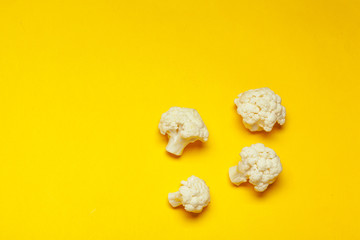 Cauliflower pieces on a bright yellow background