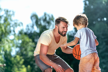 Dad and son playing basketball