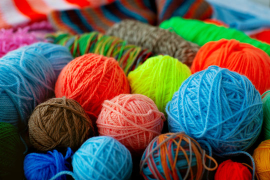 Many multicolored balls of yarn. Yarn for knitting of different colors and types. A lot of balls of yarn collected a bunch. Knitting as a kind of needlework.