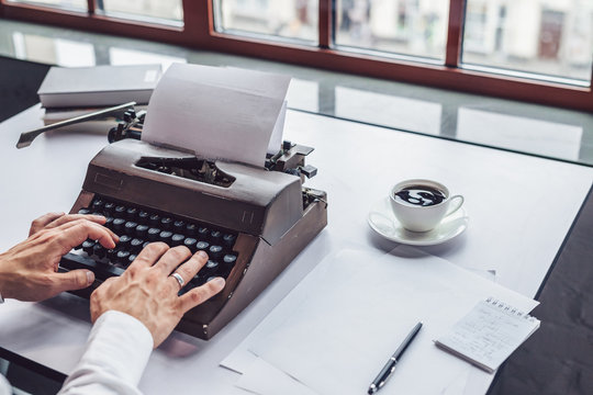Men's hands typing on a retro typewriter