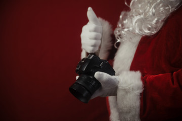 Santa Claus using DSLR camera taking images showing thumb up. Happy Christmas Evening and New Year...