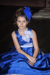 young girl princess in a blue dress with a beautiful hairstyle
