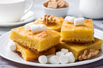 Pieces of delicious pumpkin pie with marshmallow and nuts on a plate.