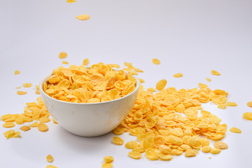Corn flakes falling to the white bowl. Motion. Copyspace.