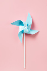 Blue paper pinweel on pink background. Energy ecological concept