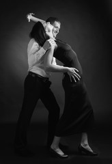 Fototapeta na wymiar Young beautiful woman in black dress and man in white shirt dancing tango.