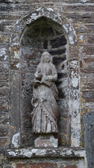 Obraz premium Lichen covered statue in a Cornish Churchyard
