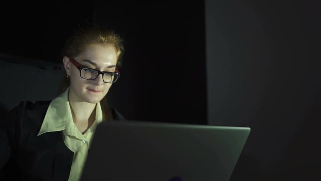  4K. Girl manager works in office at laptop. Slider shot,dolly