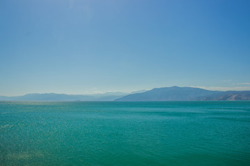 soft focus beautiful south tropic landscape of mountain ridge shape on horizon background and vivid blue and green water surface on foreground, copy space  © Artem Kniaz