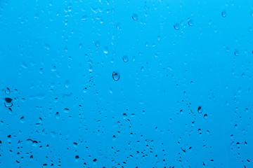 Natural water drop background on glass. Blurred city