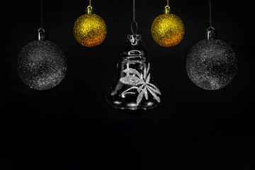 Christmas toys on the Christmas tree, golden and black on a dark background