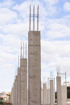 Gruppe von Betonst&uuml;tzen mit Armierungseisen auf einer Baustelle