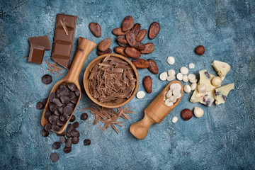 Top view of chocolate chips, bars and drops with cocoa beans for confectionery