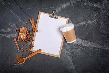 Top view of mockup composition with blank white sheet of paper with disposable take-out coffee cup and spices