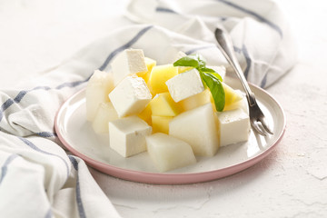 fruit salad with cheese. Mango, melon with cheese and Basil