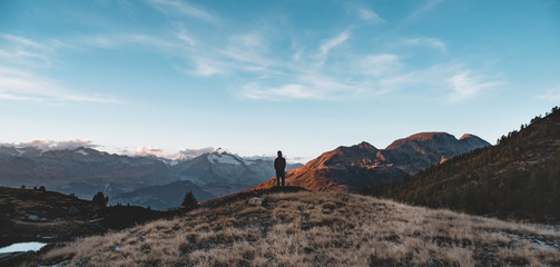 Person auf herbstlicher Bergspitze im Sonnenuntergang