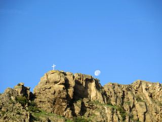 Moon and large cross on mountain