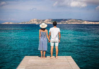 Young couple in love enjoy beautiful sea landscape on pier in Italy