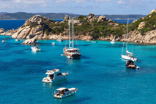 Fototapeta Yachts and boats in amazing azure sea water in Sardinia island, Italy