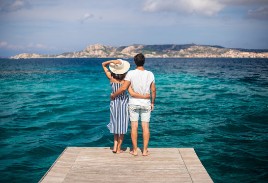 Young couple in love enjoy beautiful sea landscape on pier in Italy