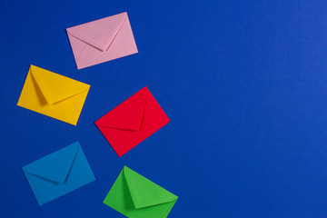 Colorful envelopes on blue background, top view