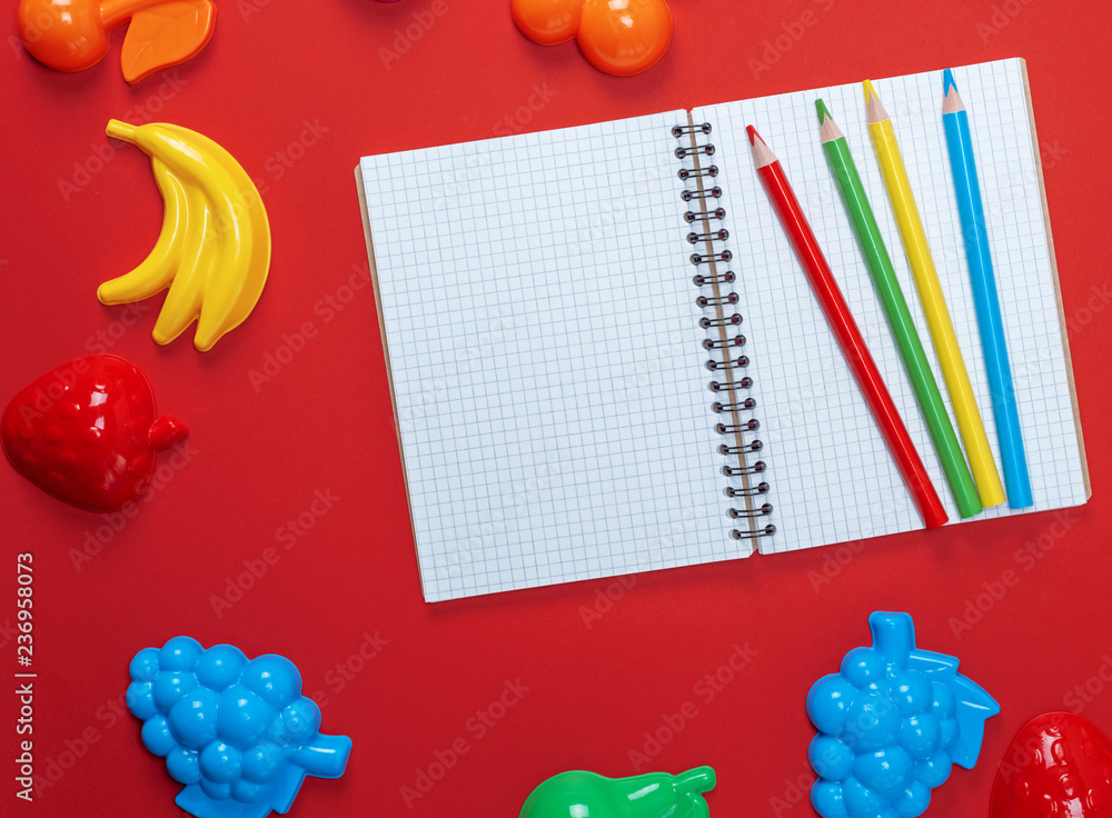 Poster open notebook with empty white sheets and multicolored wooden pencils