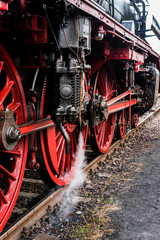 Detail of a steam locomotive with white Steam, white Steam, Detail of Big red Wheels, rod Drive