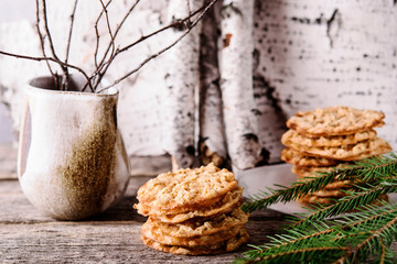 Havreflarn - scandinavian crispy slim oatmeal cookies, fir and birch branches and bark on old...