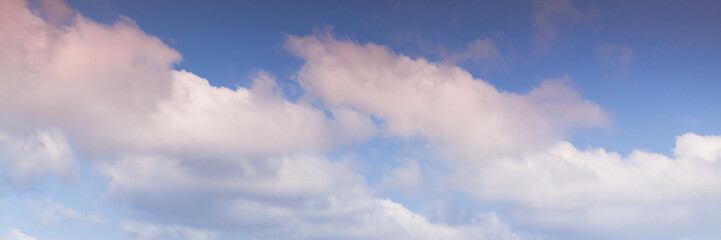 White pink clouds formation in blue sky