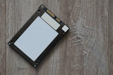 Solid State Drive (SSD) on brown background wooden copy space