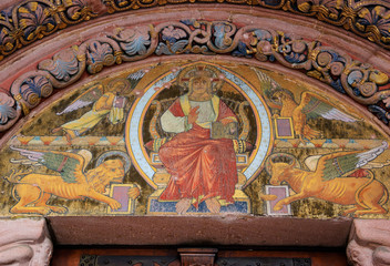 Jesus Christ surrounded by Four Evangelists (represented as winged angel, lion, ox and eagle) and the fresco above the entrance to the Church of Saint Faith in Selestat, France.  - obrazy, fototapety, plakaty