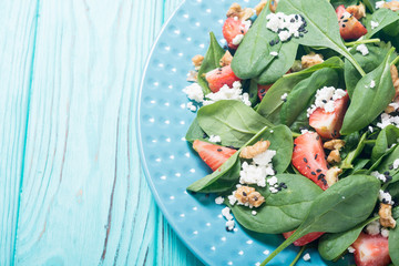Fototapeta na wymiar Strawberry salad with spinach , cheese and walnut . Healthy food