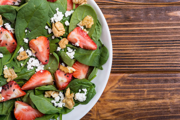 Strawberry salad with spinach , cheese and walnut . Healthy food