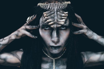 Portrait of woman in image of extraterrestrial alien with horns on her head and demonic eyes.