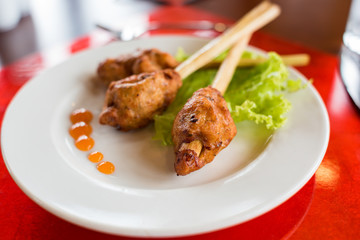 Meat on a lemongrass stick served with lettuce and hot chilli sauce