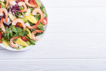 Mix of salad with shrimps , avocado and cherry tomatoes . Healthy food background