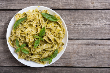 Pasta tagliatelle with green sauce pesto . Italian food background