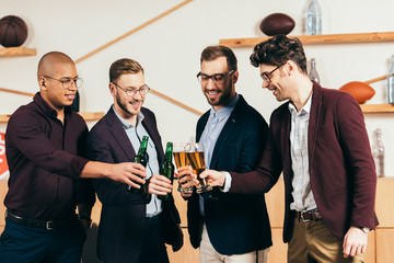 smiling multiracial business team clinking drinks while resting together in cafe