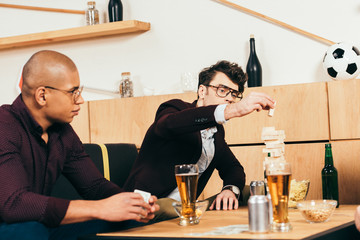 multiethnic businessmen with beer playing blocks wood game in cafe