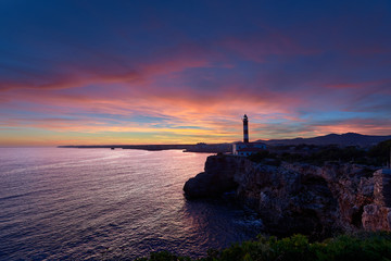Lighthouse at sunset under a splendid sky of colors and a calm sea. Mediterranean sea in Spain....