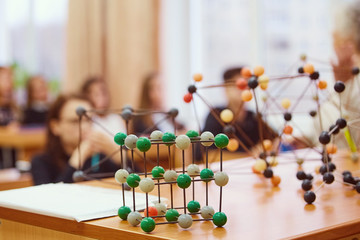 Students sit in the classroom and listen to a lecture in science. Plastic molecular educational...